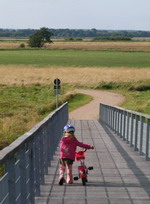 Junge Fahrradfahrerin auf der Br�cke bei Melchers H�tte